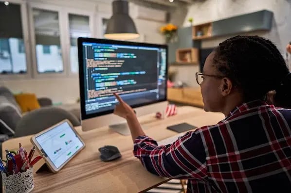 Woman looking at code on computer screen